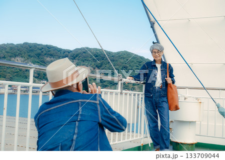 フェリーの甲板で港町を眺めるシニア夫婦の旅行ポートレート フェリーの甲板で港町を眺めるシニア夫婦の旅行ポートレート 133709044