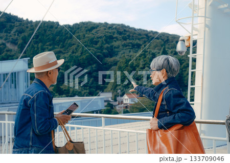 フェリーの甲板で港町を眺めるシニア夫婦の旅行ポートレート フェリーの甲板で港町を眺めるシニア夫婦の旅行ポートレート 133709046
