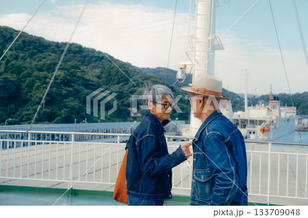 フェリーの甲板で港町を眺めるシニア夫婦の旅行ポートレート フェリーの甲板で港町を眺めるシニア夫婦の旅行ポートレート 133709048