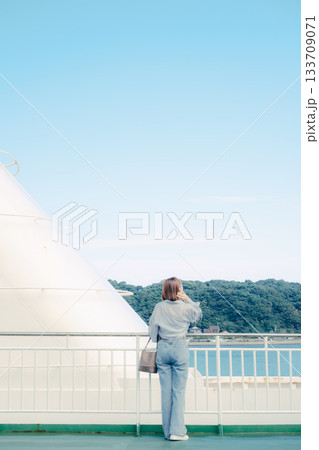 フェリーの甲板で海を眺める20代女性の旅行シーン 133709071