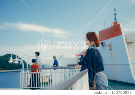 フェリーの甲板で海を眺める20代女性の旅行シーン 133709073