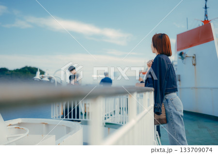 フェリーの甲板で海を眺める20代女性の旅行シーン 133709074