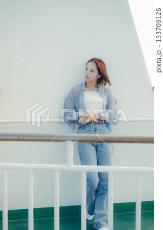 フェリーの甲板で海風を感じる20代女性の旅行シーン フェリーの甲板で海風を感じる20代女性の旅行シーン 133709126