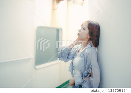 フェリーの甲板で海風を感じる20代女性の旅行シーン フェリーの甲板で海風を感じる20代女性の旅行シーン 133709134