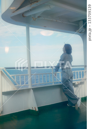 フェリーの甲板で海風を感じる20代女性の旅行シーン フェリーの甲板で海風を感じる20代女性の旅行シーン 133709139