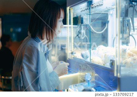 彼氏目線で見つめるクレーンゲームに夢中な20代女性 133709217