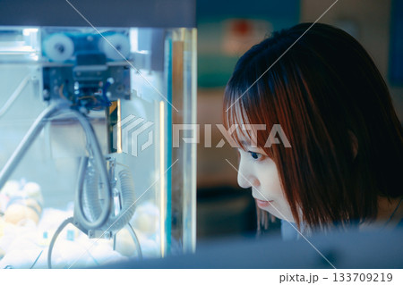 彼氏目線で見つめるクレーンゲームに夢中な20代女性 彼氏目線で見つめるクレーンゲームに夢中な20代女性 133709219