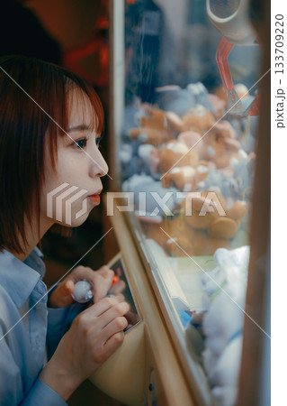 彼氏目線で見つめるクレーンゲームに夢中な20代女性 133709220