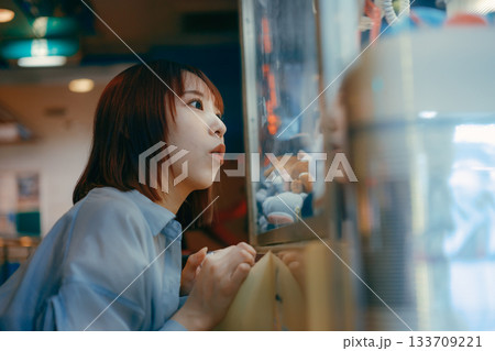 彼氏目線で見つめるクレーンゲームに夢中な20代女性 133709221