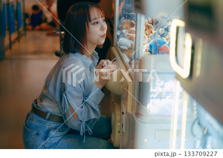 彼氏目線で見つめるクレーンゲームに夢中な20代女性 133709227