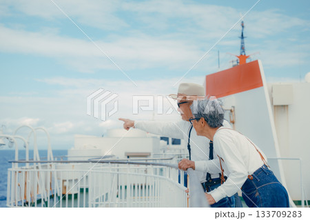 シニア夫婦が船上デッキで景色を指さす旅行シーン シニア夫婦が船上デッキで景色を指さす旅行シーン 133709283