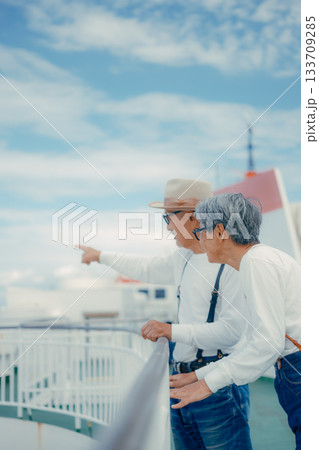 シニア夫婦が船上デッキで景色を指さす旅行シーン シニア夫婦が船上デッキで景色を指さす旅行シーン 133709285