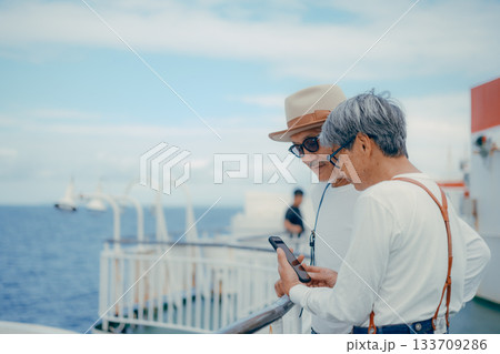 シニア夫婦が船上デッキで景色を指さす旅行シーン 133709286
