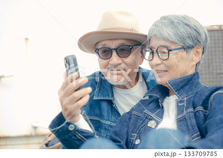 スマホを見るシニア夫婦のポートレート スマホを見るシニア夫婦のポートレート 133709785