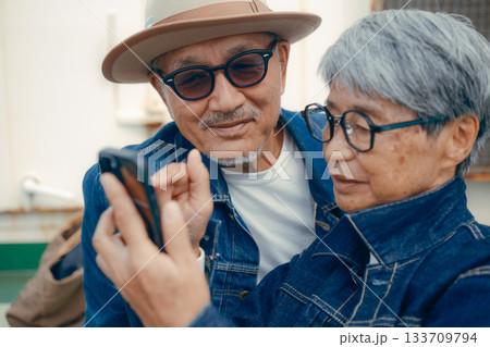 スマホを見るシニア夫婦のポートレート 133709794
