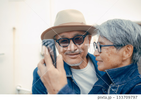 スマホを見るシニア夫婦のポートレート スマホを見るシニア夫婦のポートレート 133709797
