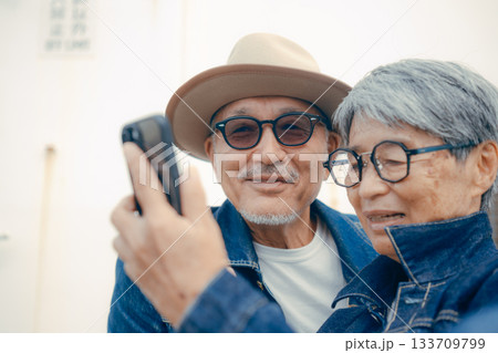 スマホを見るシニア夫婦のポートレート スマホを見るシニア夫婦のポートレート 133709799