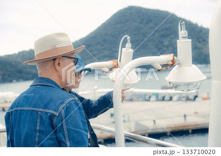 フェリーから港町を眺めるシニア夫婦の後ろ姿 133710020