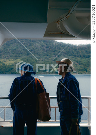 フェリーから港町を眺めるシニア夫婦の後ろ姿 133710021
