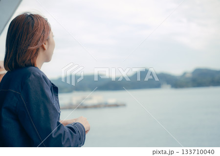 フェリーのデッキから海を眺める女性の後ろ姿 133710040
