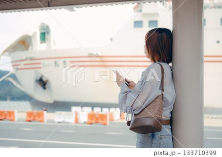 フェリー乗り場でスマートフォンを見る女性 フェリー乗り場でスマートフォンを見る女性 133710399
