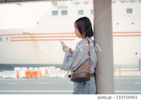フェリー乗り場でスマートフォンを見る女性 133710401