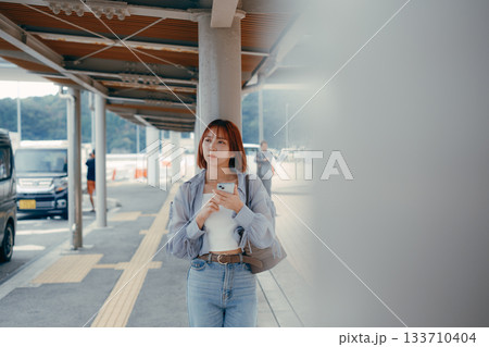 フェリー乗り場でスマートフォンを見る女性 133710404