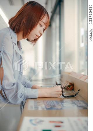 窓口で書類に記入する女性 133710459