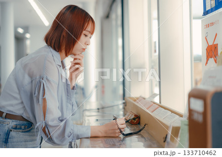 窓口で書類に記入する女性 窓口で書類に記入する女性 133710462