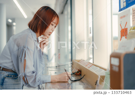 窓口で書類に記入する女性 133710463