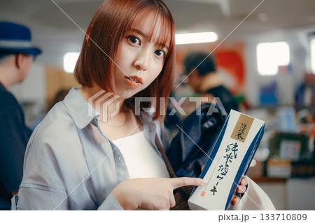 お土産コーナーで商品を手に取る女性 お土産コーナーで商品を手に取る女性 133710809
