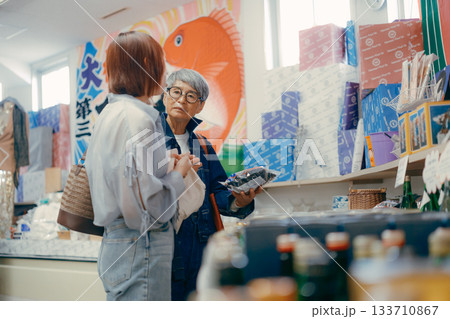店内で商品を手に取って確認する親子二人 133710867