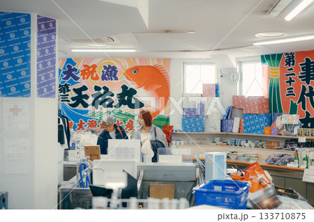 店内で商品を手に取って確認する親子二人 133710875