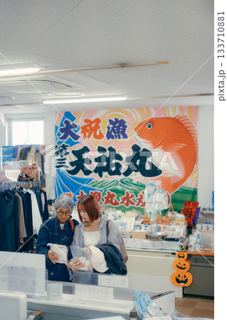 店内で商品を手に取って確認する親子二人 店内で商品を手に取って確認する親子二人 133710881