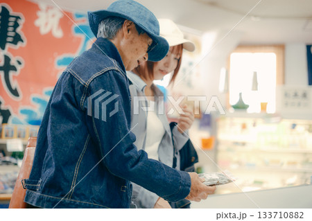 店内で商品を手に取って確認する親子二人 店内で商品を手に取って確認する親子二人 133710882