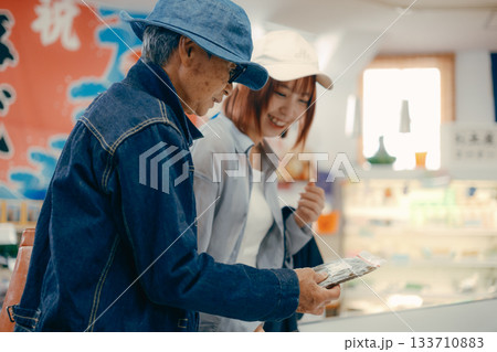 店内で商品を手に取って確認する親子二人 店内で商品を手に取って確認する親子二人 133710883