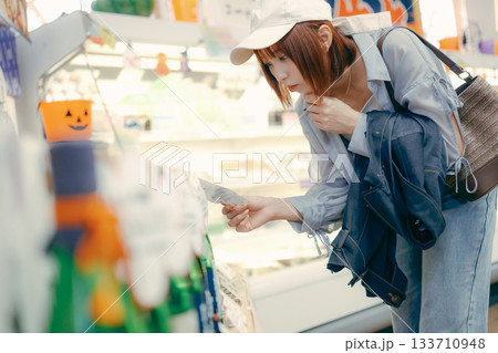 店内で商品を確かめる女性の横姿 133710948