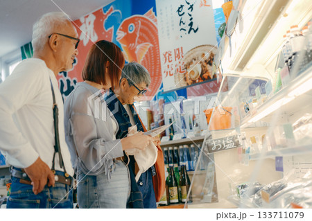 店内で商品を見ながら話す三人の姿 店内で商品を見ながら話す三人の姿 133711079