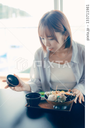 海鮮丼を前にした20代女性のランチ前シーン 133711981