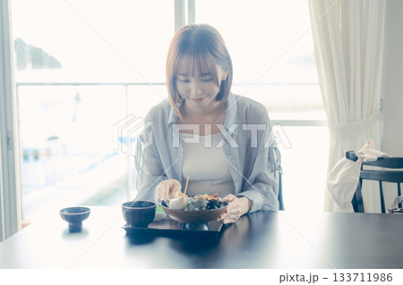 海鮮丼を前にした20代女性のランチ前シーン 海鮮丼を前にした20代女性のランチ前シーン 133711986