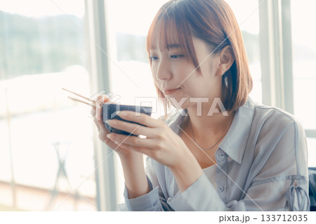 海鮮丼を味わう20代女性の食事シーン 133712035