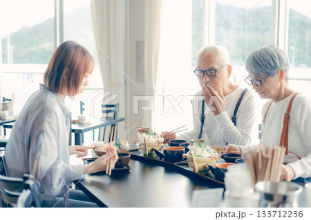 旅行先で海鮮料理を楽しむ親子3人の食事シーン 133712236
