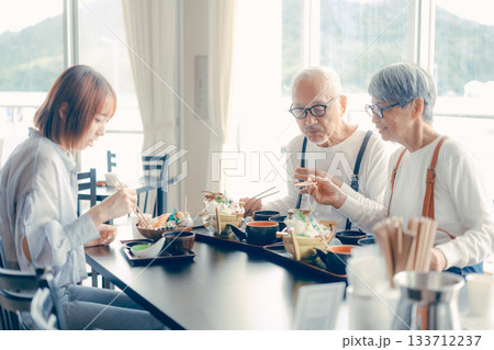 旅行先で海鮮料理を楽しむ親子3人の食事シーン 133712237
