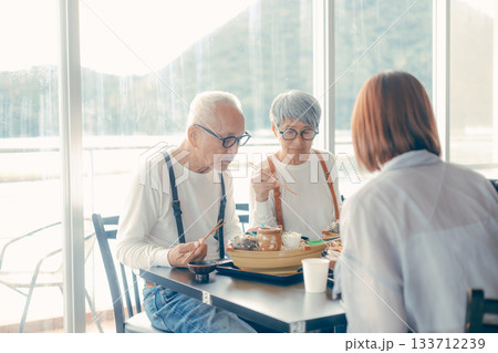 旅行先で海鮮料理を楽しむ親子3人の食事シーン 旅行先で海鮮料理を楽しむ親子3人の食事シーン 133712239