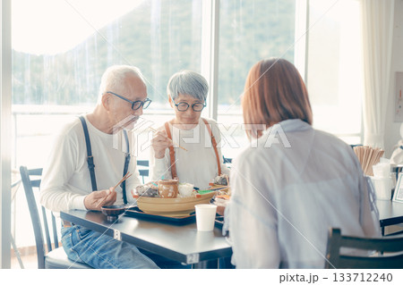 旅行先で海鮮料理を楽しむ親子3人の食事シーン 133712240