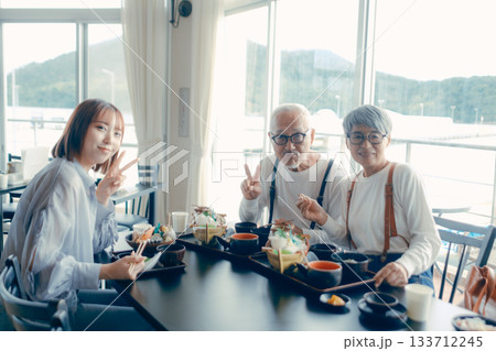 旅行先で海鮮料理を楽しむ親子3人の食事シーン 133712245