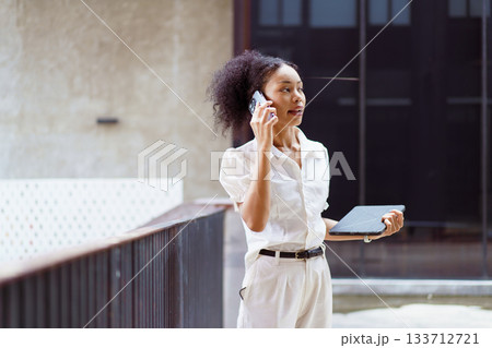 African black businesswoman walking on the street in city. African black businesswoman walking on the street in city. 133712721