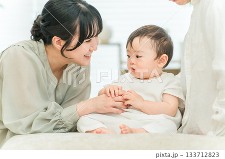マイホームのリビングソファーで赤ちゃんと過ごす若いファミリー,家族 マイホームのリビングソファーで赤ちゃんと過ごす若いファミリー,家族 133712823