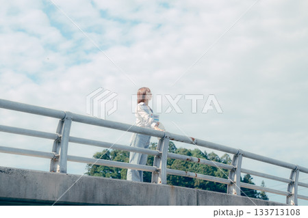 橋の上で空を見上げる20代女性のポートレート 橋の上で空を見上げる20代女性のポートレート 133713108