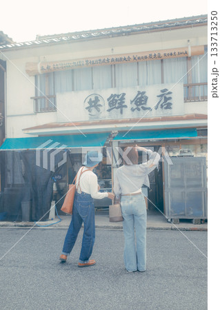 60代シニアと20代女性が旅先でスマホを見るシーン 60代シニアと20代女性が旅先でスマホを見るシーン 133713250